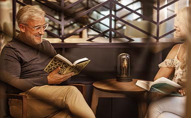 A couple relaxing with a book in the library on Spirit of the Rhine A couple relaxing with a book in the library on Spirit of the Rhine